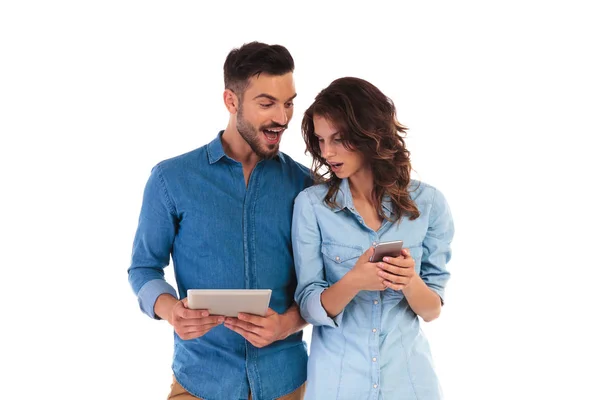 Surprised casual man showing good news to girlfriend on tablet — Stock Photo, Image