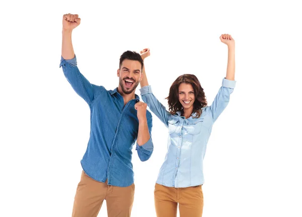 Feliz jovem casal celebrando o sucesso com as mãos para cima — Fotografia de Stock