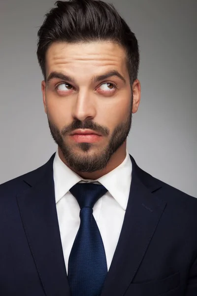 Portrait d'un jeune homme d'affaires réfléchissant et levant les yeux — Photo