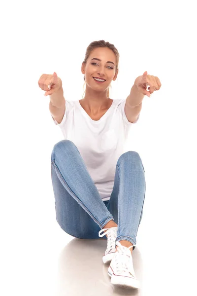 Mulher casual feliz sentado e apontando dedos — Fotografia de Stock