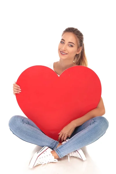 Feliz en el amor chica joven sosteniendo gran corazón rojo —  Fotos de Stock