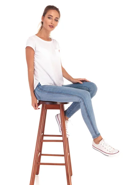 Junge blonde Frau sitzt auf einem Schemel — Stockfoto