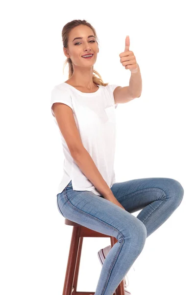 快乐随便的女人，坐在凳子上制作 ok 的手势 — 图库照片