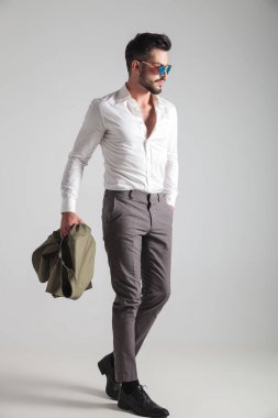 cebinde el ile yürüyen bir adam yan görünüm