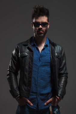 deri ceket ayakta elleri ceplerinde giyen adam