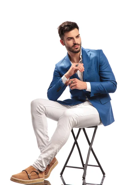 Sitzender eleganter Mann, der seinen Ärmel fixiert — Stockfoto