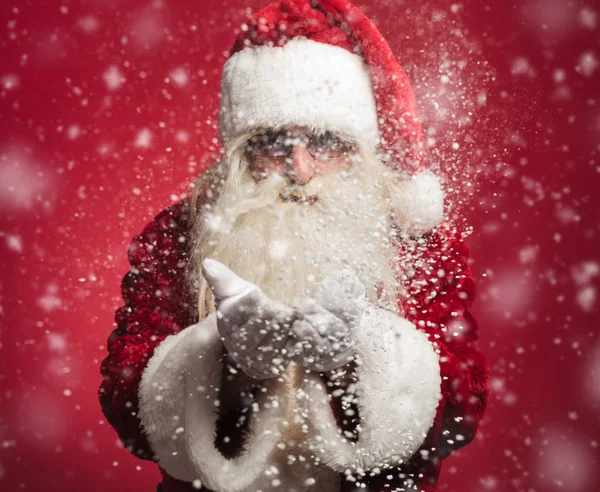 Santa claus blåser snö flingor händerna — Stockfoto