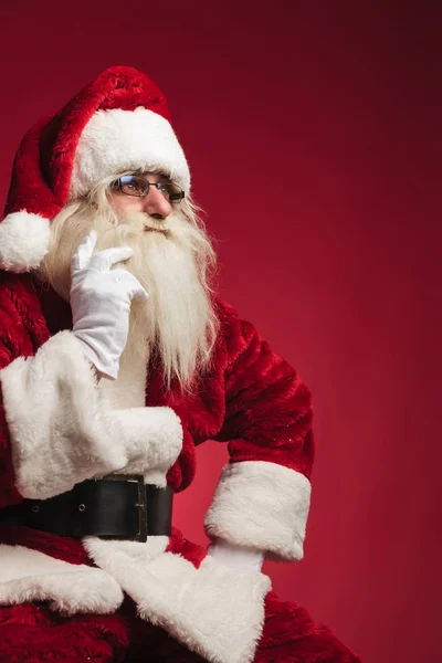 Cutout image of a thoughtful santa claus sitting — Stock Photo, Image