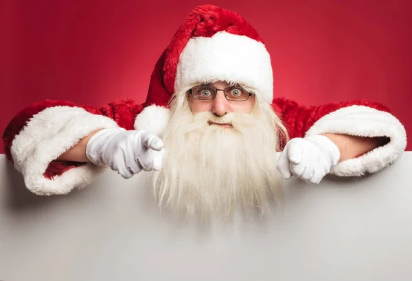 Взволнованная Санта хлопает по билборду, показывая пальцами — стоковое фото