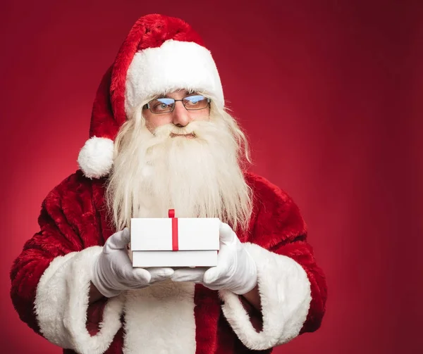 圣诞老人手持礼品盒的侧面图 — 图库照片