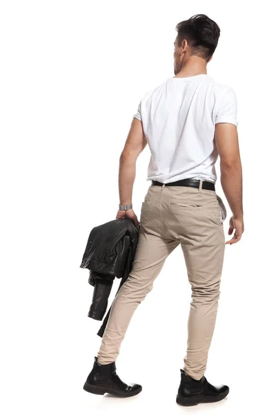 Vista posterior de hombre sexy sosteniendo chaqueta y paseos — Foto de Stock