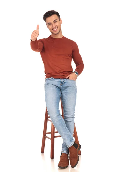 Щасливий чоловік сидить на табуреті роблячи знак ОК — стокове фото
