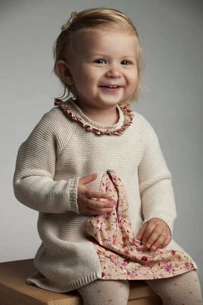 Lado de una niña pequeña con vestido de punto y riendo —  Fotos de Stock