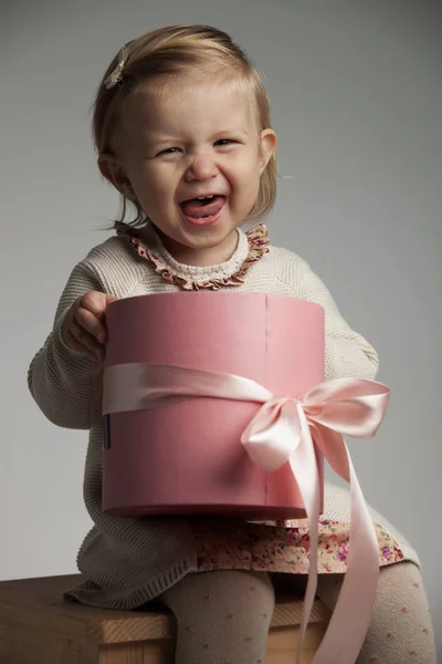 Szuper izgatott kis lány sikoltozik, míg a gazdaság egy rózsaszín doboz — Stock Fotó
