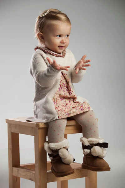 Küçük kız elleriyle işaret oturmuş — Stok fotoğraf