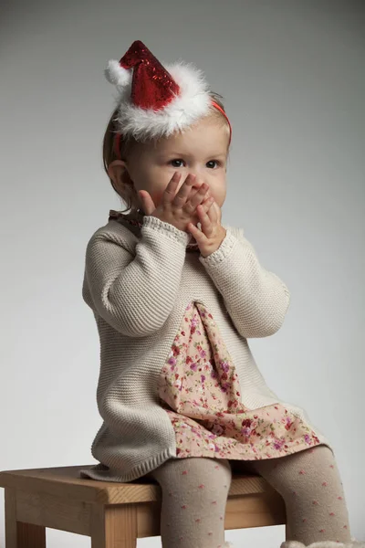 女孩的手掌超过她的嘴期待圣诞老人 — 图库照片