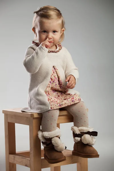 Adorável menina escolhendo seu nariz enquanto sentado — Fotografia de Stock