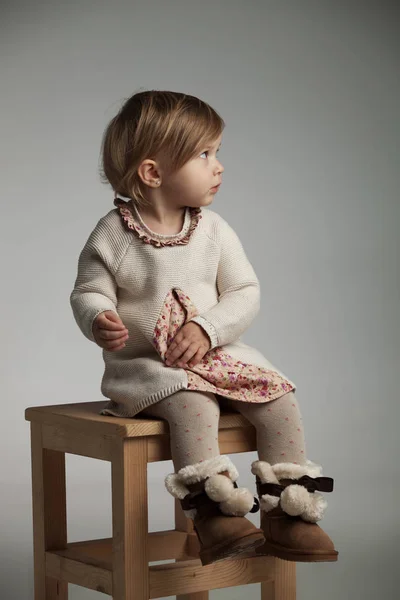 Zijaanzicht van een schattig klein meisje zittend op een stoel — Stockfoto