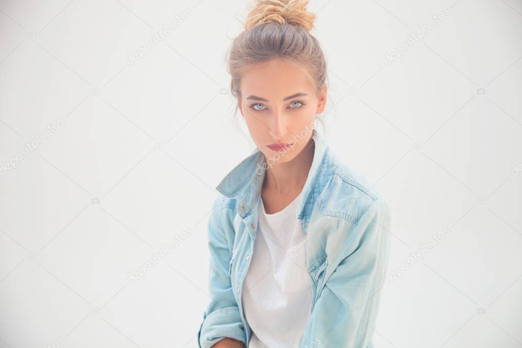 portrait of a blue eyed blonde in jeans shirt