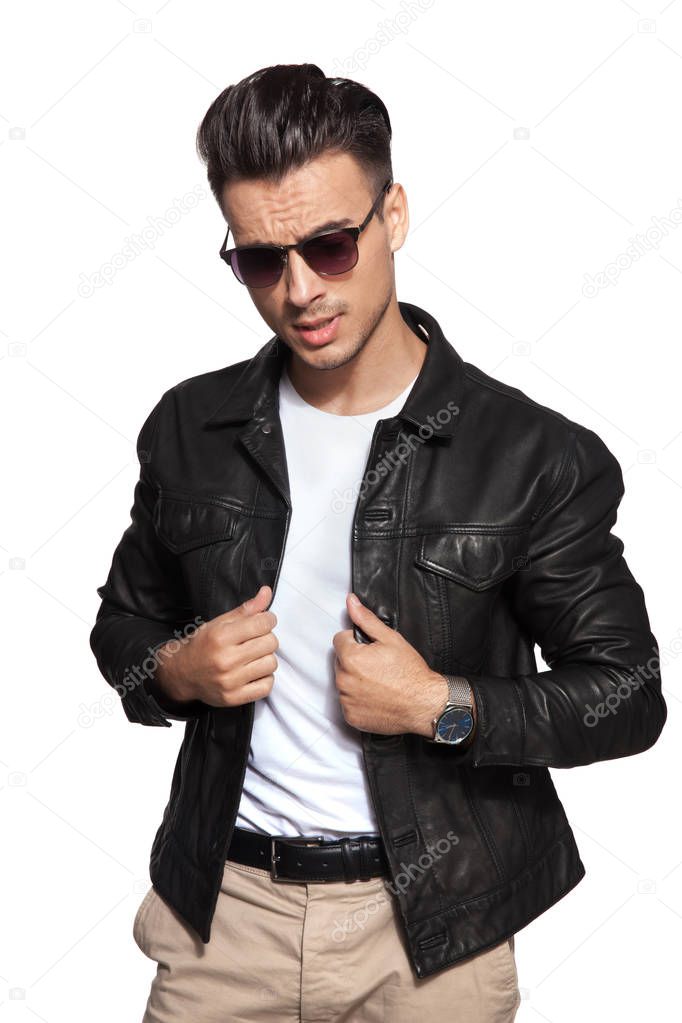 cool young fashion man pulling leather jacket's collar 