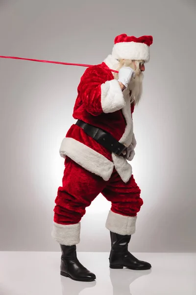 Санта Клаус тянет красную веревку — стоковое фото