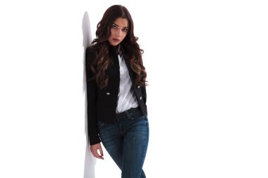 Beyaz duvara yaslanmış ciddi moda kadın