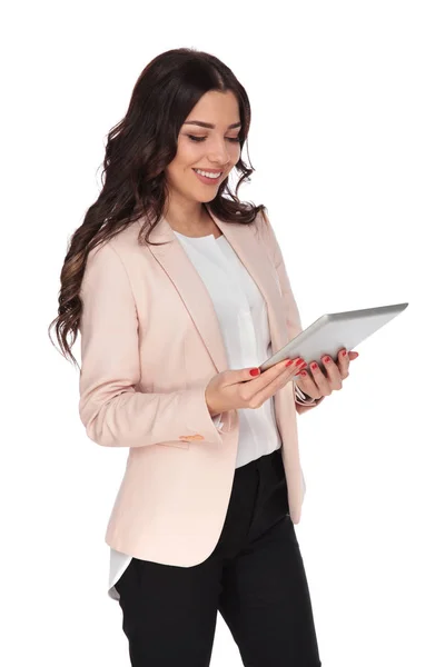 Happy young woman holding a tablet and smiles — Stock Photo, Image