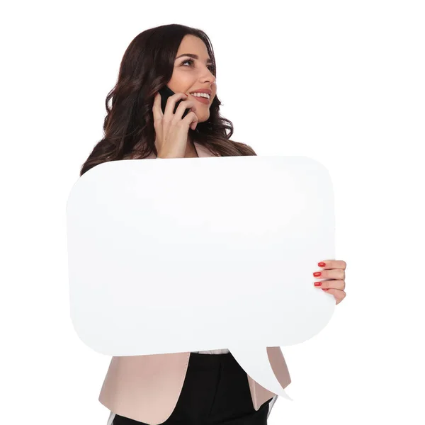 Woman speaking on the phone and holding a talk bubble — Stock Photo, Image