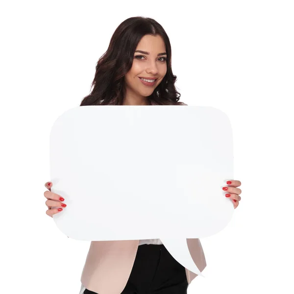 Sorridente jovem empresária segurando uma bolha de discurso em branco — Fotografia de Stock