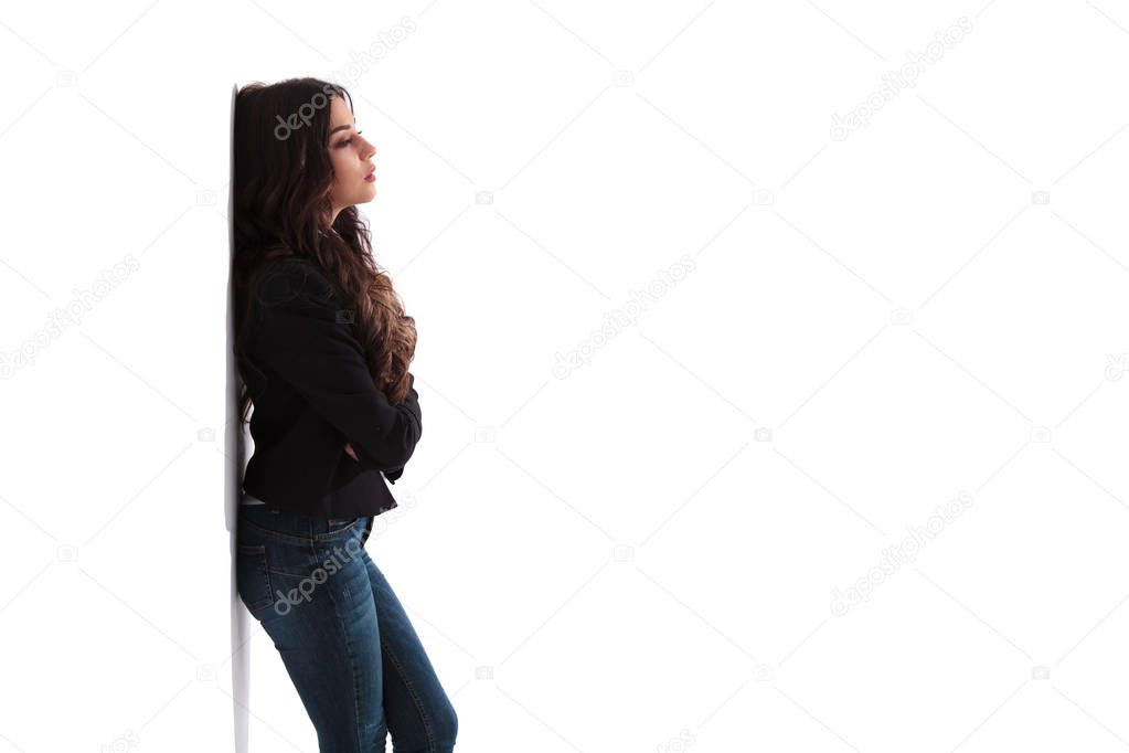 side view of a pensive woman standing with hands crossed 