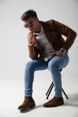 düşünceli genç casual adam bir sandalyede oturuyor