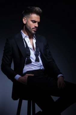 Smokin cebinde el ile oturan genç adam