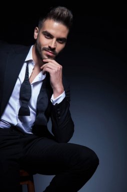 adam smokin çözülmüş papyon ile gülümseyen ve düşünme