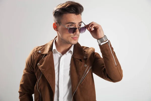 Joven hombre casual que se pone sus gafas de sol — Foto de Stock