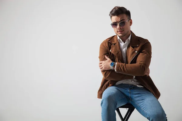 Cooler Modemann sitzt mit gekreuzten Händen — Stockfoto