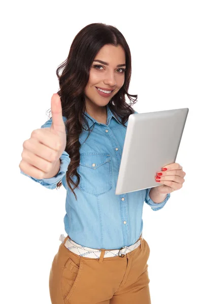 Smiling casual woman holding tablet makes ok sign — Stock Photo, Image
