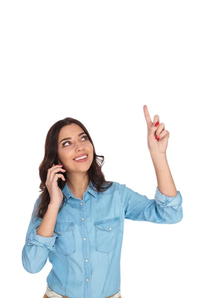 Молода щаслива випадкова жінка розмовляє по телефону вказує на присутність — стокове фото
