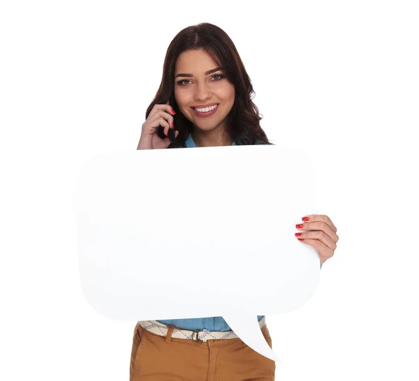 Woman talking on the phone and holding a speech bubble — Stock Photo, Image