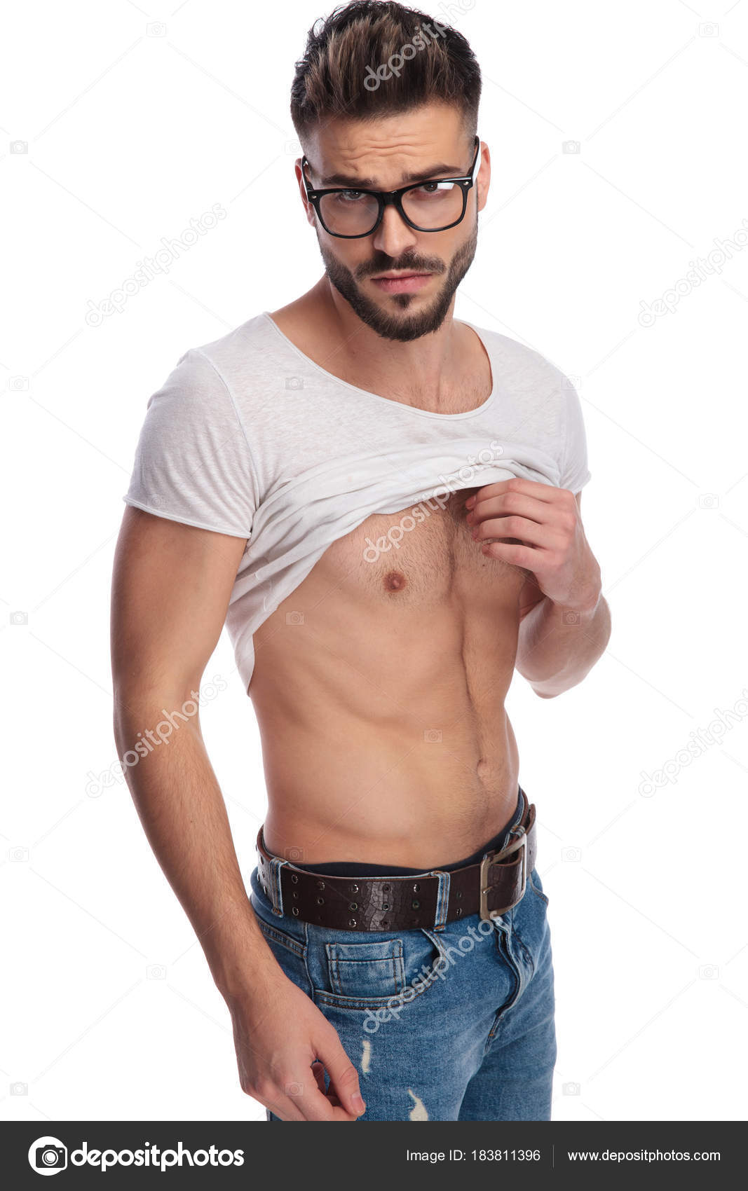 Cool young man lifting his tshirt to show you abs Stock Photo by