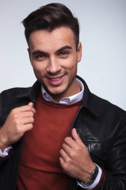 tasmasını çekerek gülümseyen genç moda adam 