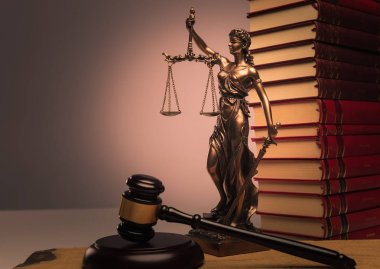 Hukuk kitapları, adalet heykeli ve tahta tokmak