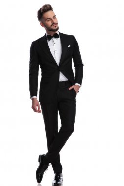 Smokin ayakta adam cebinde el ile uzak görünüyor