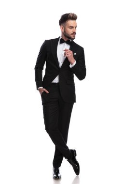 Smokin serin genç adam düşünüyor ve tarafına görünüyor