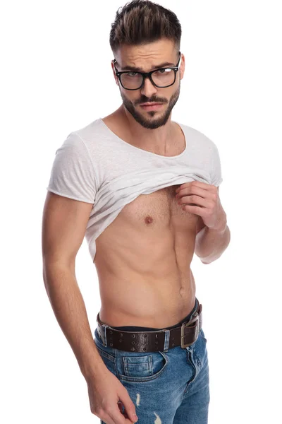 Cooler junger Mann hebt sein T-Shirt, um dir Bauchmuskeln zu zeigen — Stockfoto
