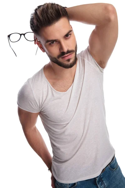 Sexy hombre casual sosteniendo gafas en la mano y detrás de la cabeza —  Fotos de Stock