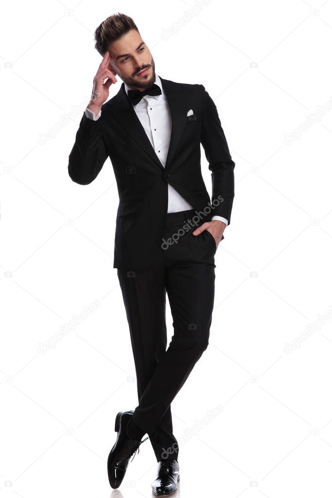 smiling man in tuxedo with hand on forehead is dreaming 