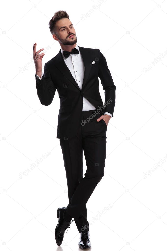 arrogant man in tuxedo is gesturing 