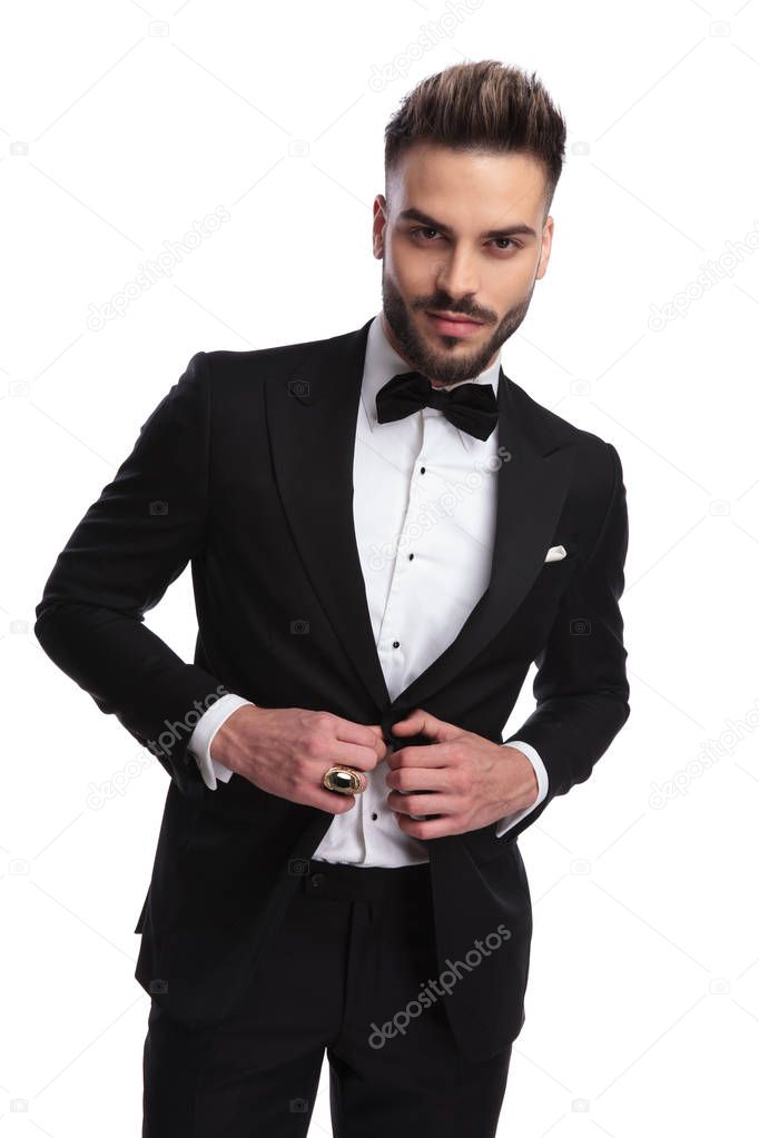cool modern man in tuxedo holds button 
