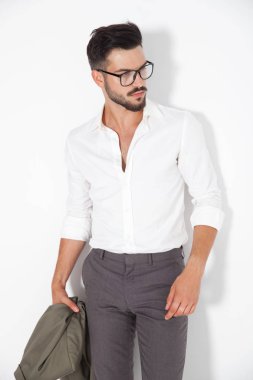 yakışıklı delikanlı holding ceket ve yan görünüyor 