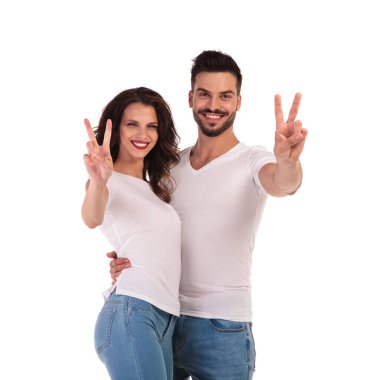 Zafer ya da barış işareti yaparak genç casual çift gülümseyen